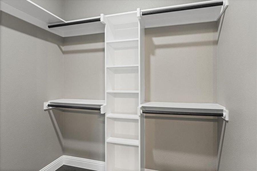 Spacious primary closet with built in cubicles for additional storage for shoes, clothes, etc.