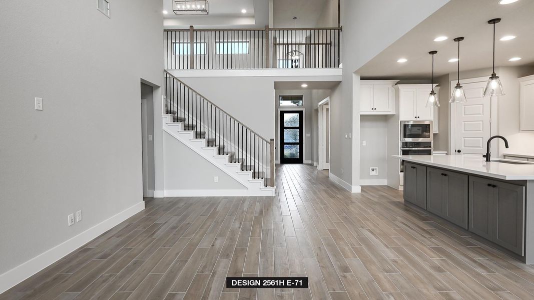 Kitchen with white cabinetry, sink, decorative light fixtures, and a high ceiling