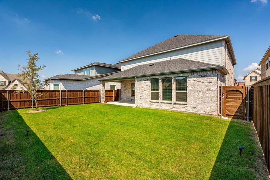 Back of property with a lawn and a patio area