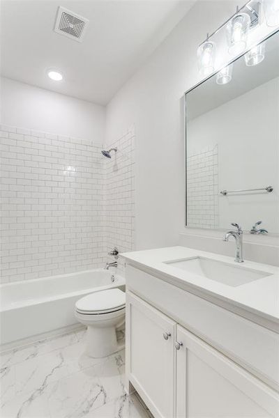 Full bathroom featuring tiled shower / bath, toilet, and vanity