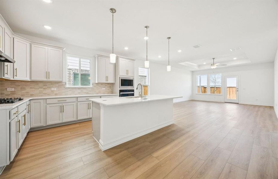 Large island overlooking gathering room and dining areas