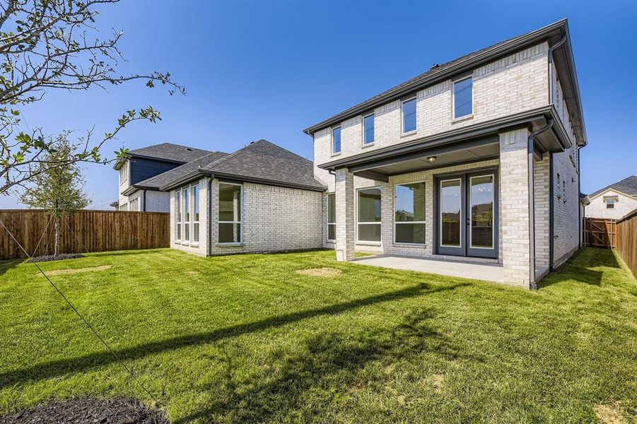 Back of property featuring a fenced backyard, brick siding, and a patio Back of property featuring a fenced backyard, brick siding, and a patio