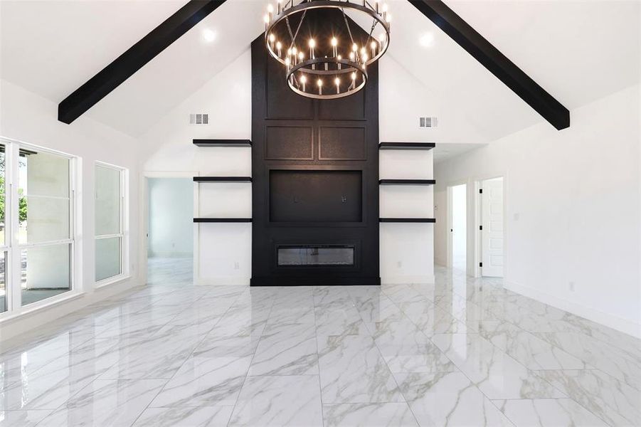 Vaulted ceilings with exposed dark beams, a central chandelier, and a prominent dark wood-paneled feature wall with integrated shelving create a striking focal point