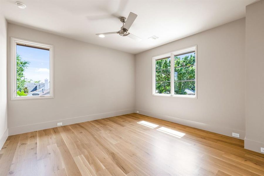 Spare room featuring a ceiling fan, wood finished floors, and a smoke detector Spare room featuring a ceiling fan, wood finished floors, and a smoke detector