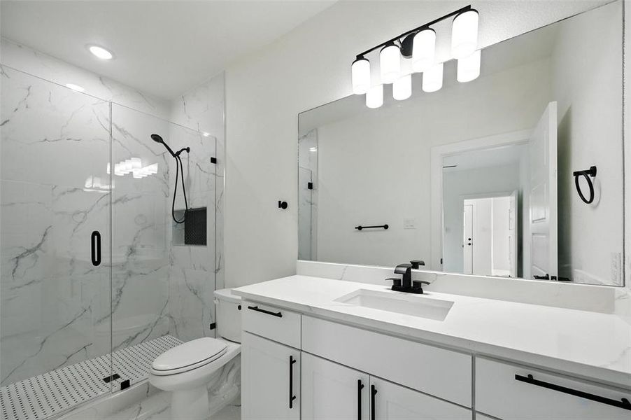 Bathroom featuring a marble finish shower, vanity, and marble look tile flooring
