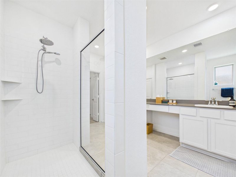 Look at this amazing walk-in shower with a rain head and hand held sprayer and glass wall overlooking the large vanity.