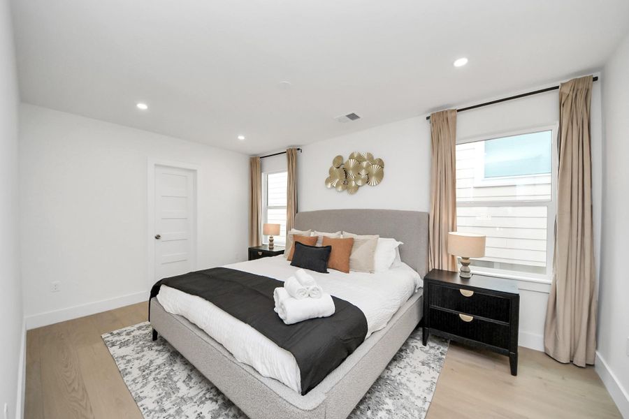 Secondary bedroom #2 upstairs easily accommodates a king size bed and shares a bathroom. It has ample natural light from two windows and is complemented by recessed lighting. Secondary bedroom #2 upstairs easily accommodates a king size bed and shares a bathroom. It has ample natural light from two windows and is complemented by recessed lighting.