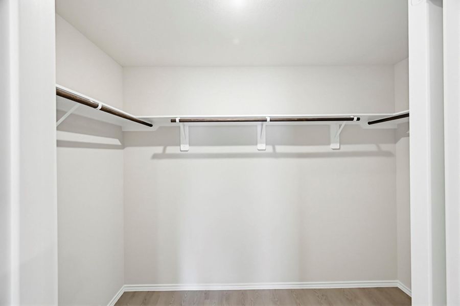 Large walk-in closet with ample hanging space and room to keep everything organized.