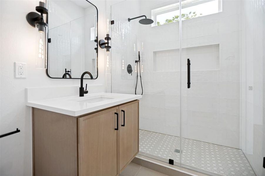 Contemporary bathroom featuring a light wood-finish vanity with a white countertop and integrated sink