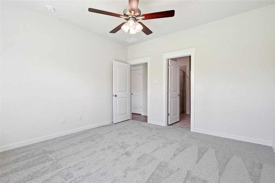 Unfurnished bedroom featuring ceiling fan and light colored carpet