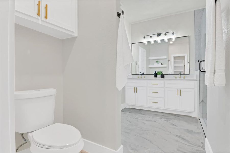 Bathroom featuring vanity, toilet, and a shower with shower door