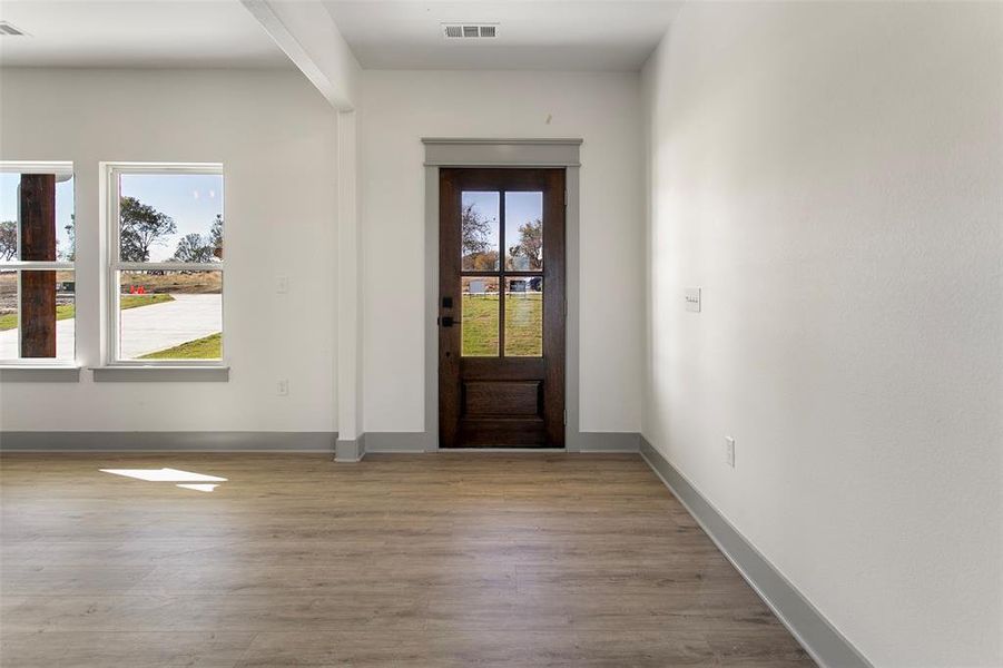 Entryway with wood finished floors and baseboards