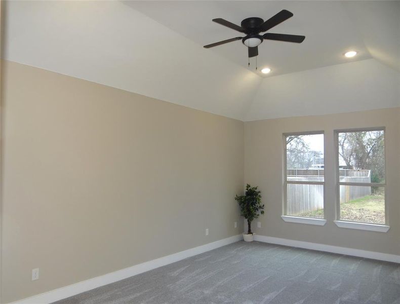 Master bedroom with ceiling fan and lofted ceiling