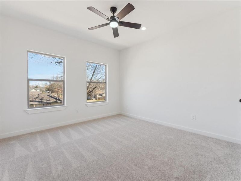 Unfurnished room with light carpet, ceiling fan, and baseboards