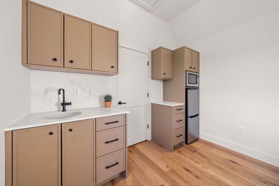 Detached studio space has a kitchenette with refrigerator/freezer,  smart multi-oven, and sink.