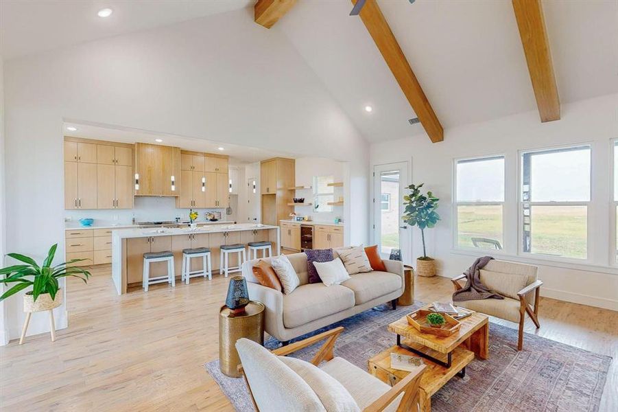 Living room with high vaulted ceiling, light wood-type flooring, and beam ceiling