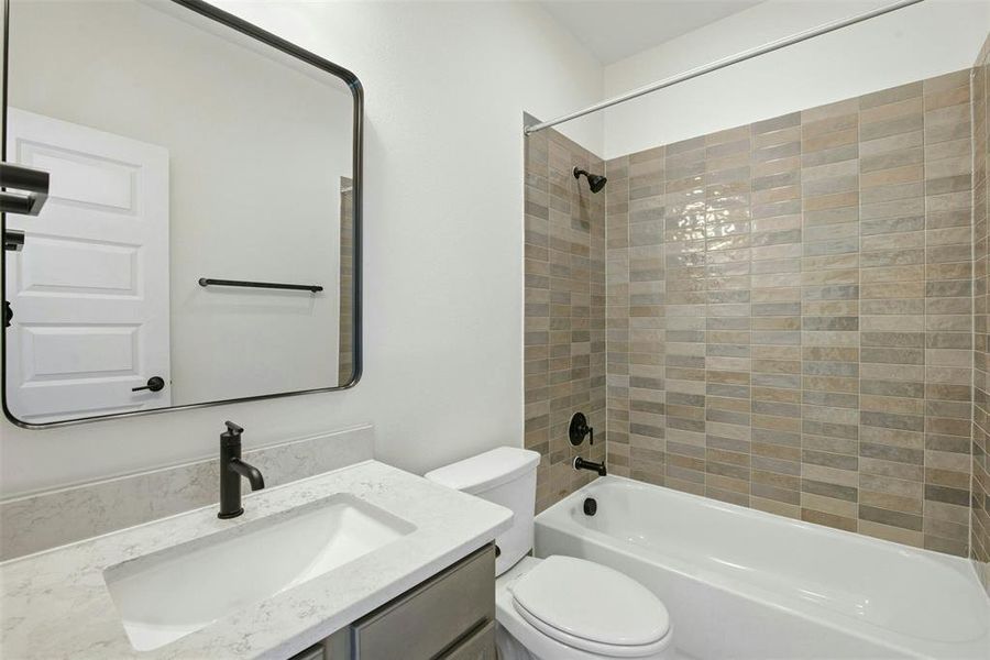Contemporary bathroom featuring a vanity with an integrated sink, a light-toned countertop, and a sleek matte black faucet