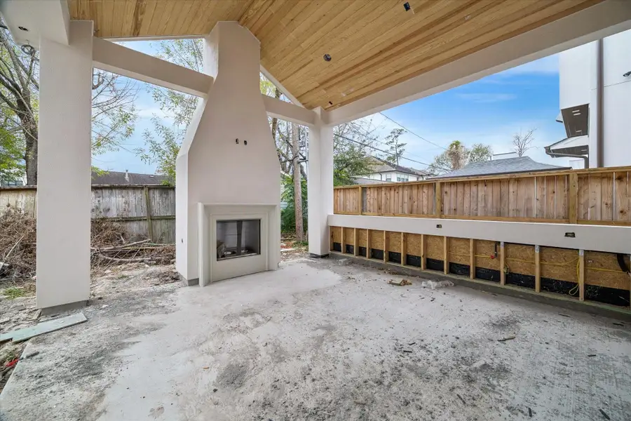 Stunning outdoor living space featuring a grand floor-to-ceiling fireplace with a modern stucco finish. This expansive covered patio boasts a sophisticated wood-plank ceiling and premium recessed lighting, creating the ultimate environment for year-round entertaining. With its clean lines and seamless connection to the interior, this private retreat exemplifies luxury contemporary design. Stunning outdoor living space featuring a grand floor-to-ceiling fireplace with a modern stucco finish. This expansive covered patio boasts a sophisticated wood-plank ceiling and premium recessed lighting, creating the ultimate environment for year-round entertaining. With its clean lines and seamless connection to the interior, this private retreat exemplifies luxury contemporary design.
