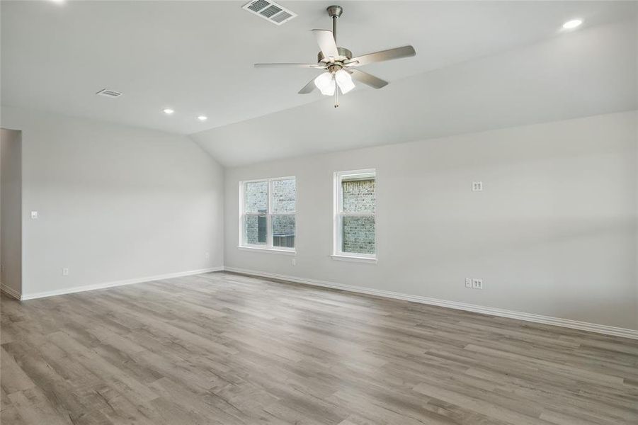 Unfurnished room featuring recessed lighting, lofted ceiling, ceiling fan, and light wood-style flooring Unfurnished room featuring recessed lighting, lofted ceiling, ceiling fan, and light wood-style flooring