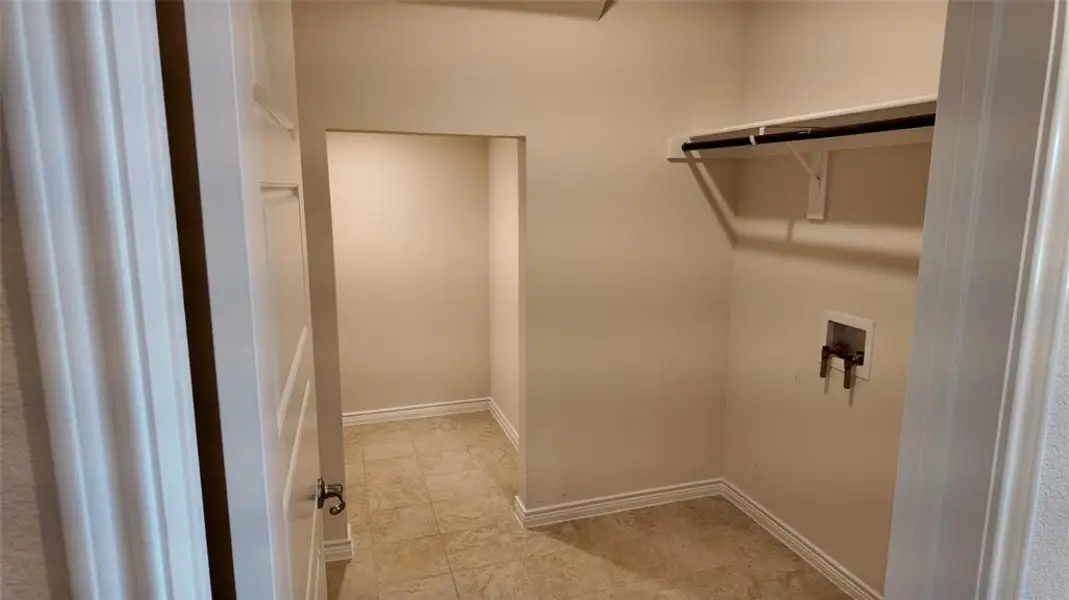 Laundry area featuring hookup for a washing machine and light tile patterned floors