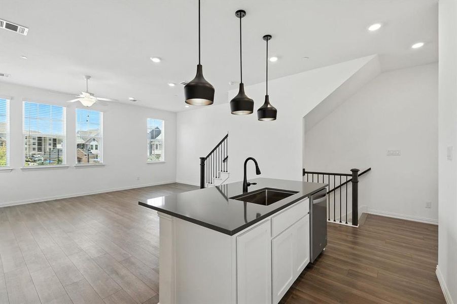 Attractive quartz counter top , farmhouse sink and decorative lighting from a premium collection.