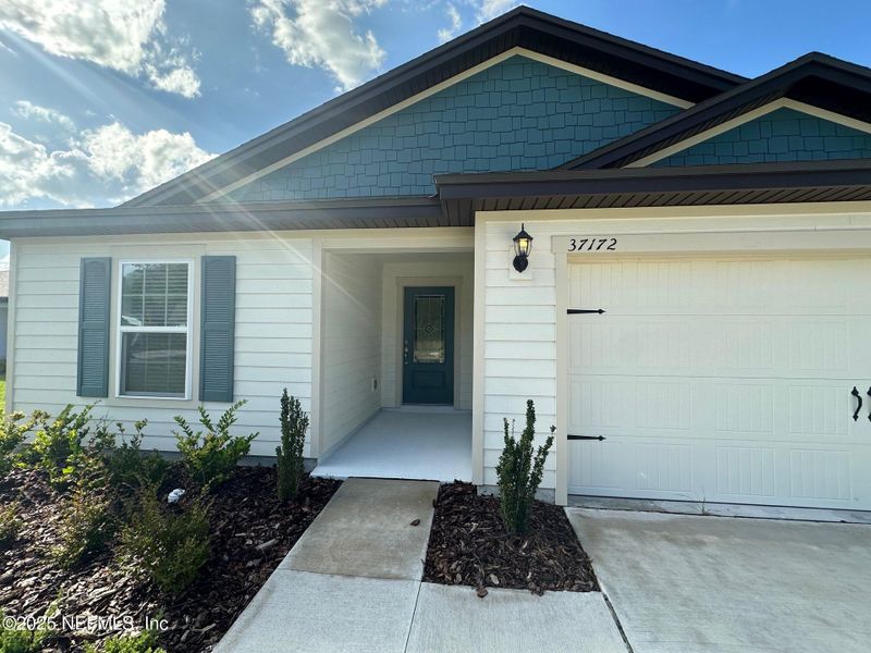 Front exterior of a new home in Whisper Ridge, Hilliard, FL, highlighting curb appeal (Image 2). Front exterior of a new home in Whisper Ridge, Hilliard, FL, highlighting curb appeal (Image 2).