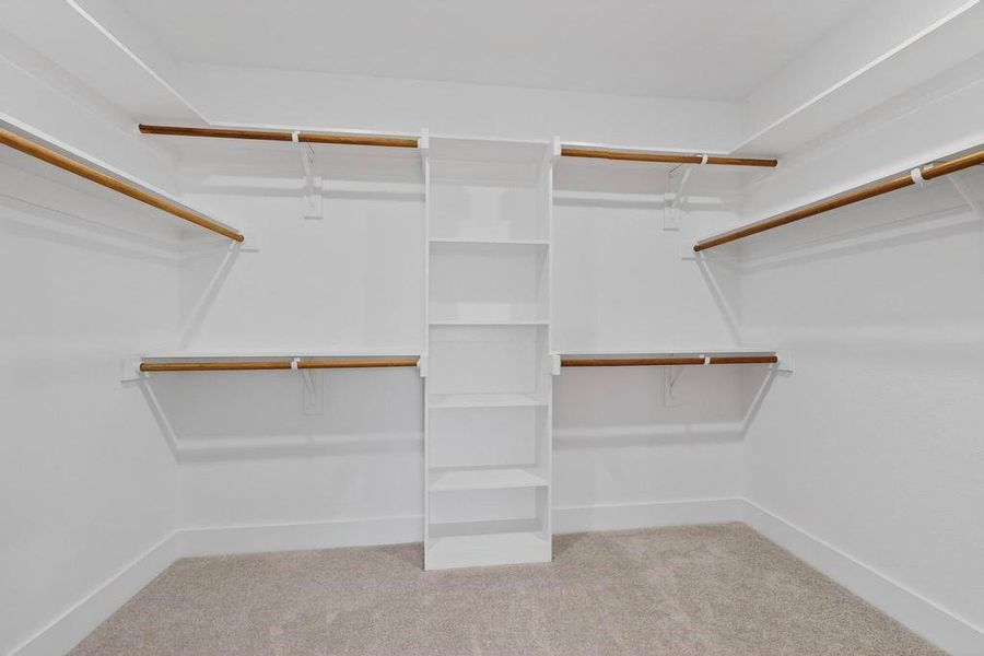 Primary Walk in closet with light colored carpet Primary Walk in closet with light colored carpet