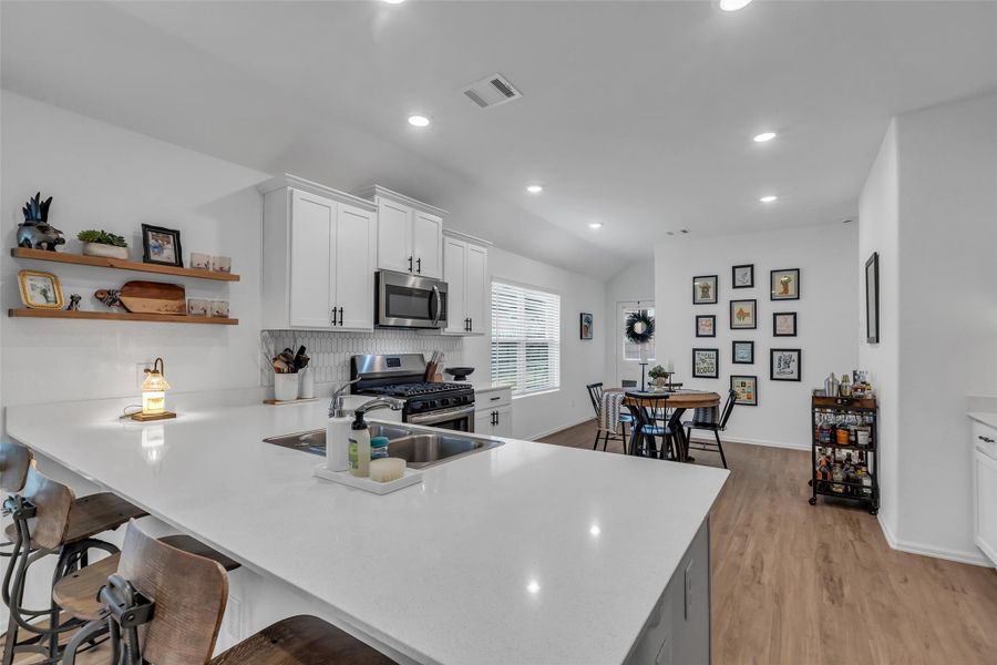 This kitchen has lots of cabinet storage, cute open shelving, and a large walk in pantry.