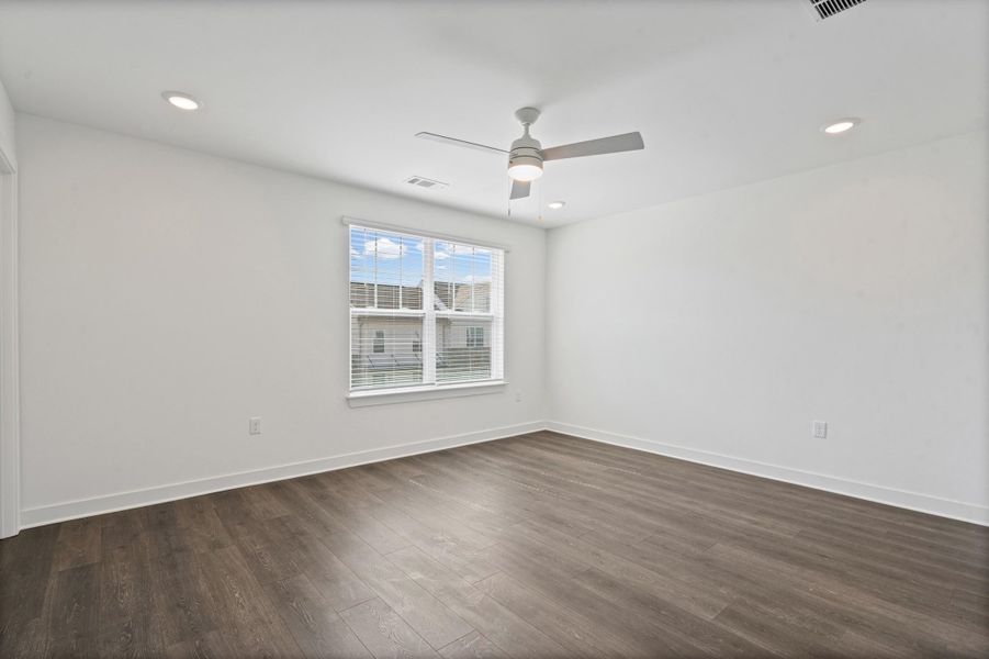 Wood-finish flooring with white baseboards, recessed ceiling lighting, and a modern ceiling fan Wood-finish flooring with white baseboards, recessed ceiling lighting, and a modern ceiling fan