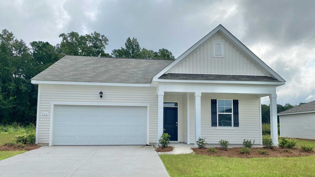 Front exterior of a new home in The Meadows at Wildwood Village, Shallotte, NC, highlighting curb appeal (Image 1).