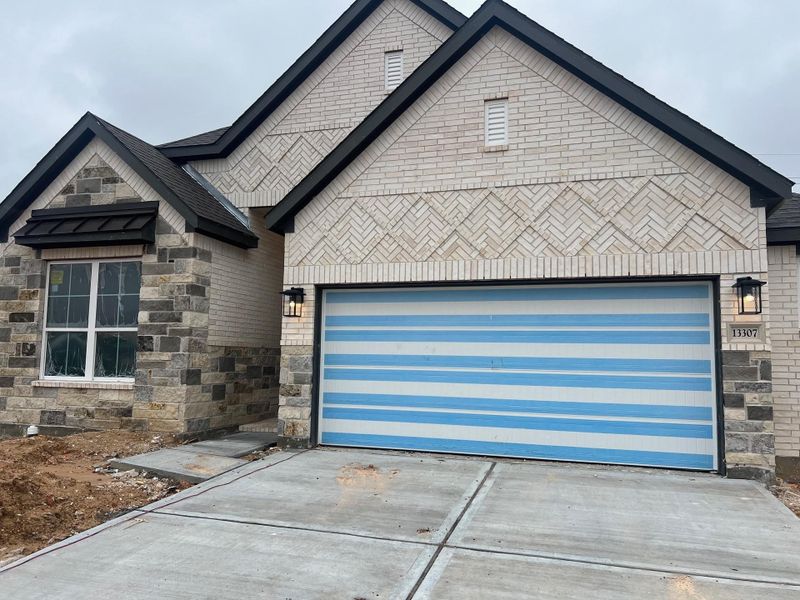 Front exterior of a new home in Wood Leaf Reserve, Tomball, TX, highlighting curb appeal (Image 1).
