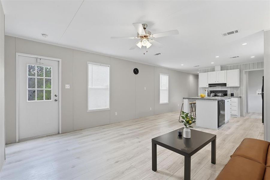 Living room with light wood-type flooring, ceiling fan, and recessed lighting Living room with light wood-type flooring, ceiling fan, and recessed lighting