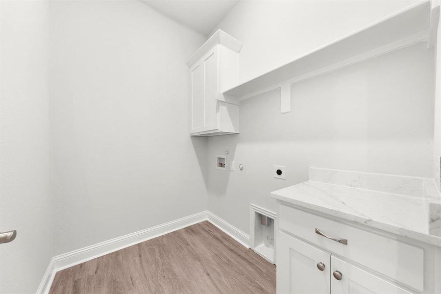 Laundry area featuring washer and dryer hookup, luxury vinyl floors, cabinet, and granite countertop.
