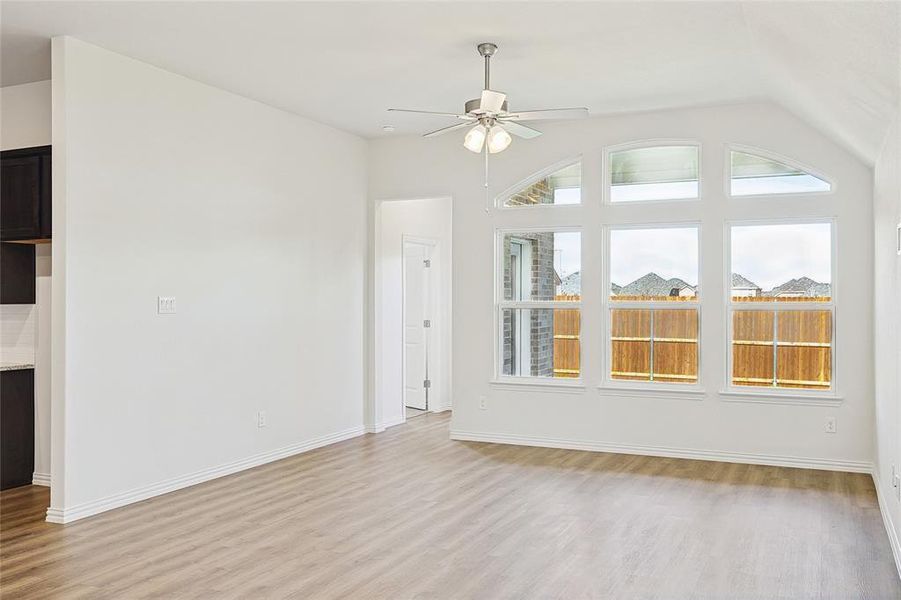 Unfurnished living room with ceiling fan, light hardwood / wood-style floors, and vaulted ceiling