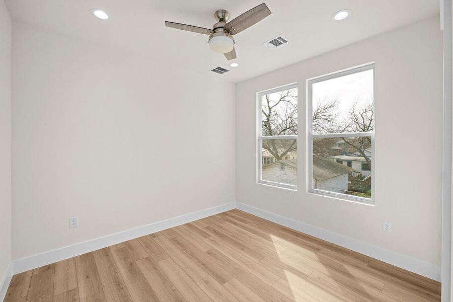 Bedroom #4 with light wood finished floors, recessed lighting, and ceiling fan.