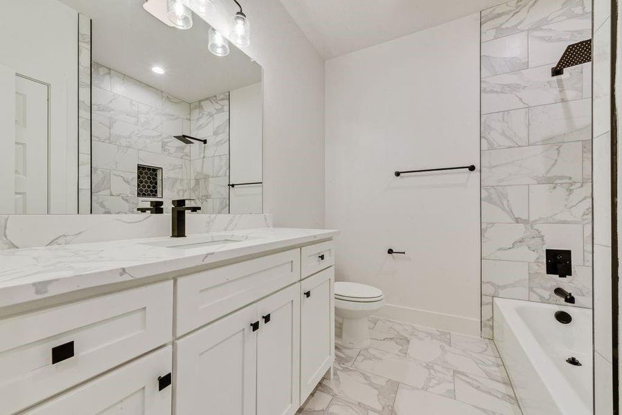 Full bath with light marble finish flooring, vanity, and tub / shower combination Full bath with light marble finish flooring, vanity, and tub / shower combination