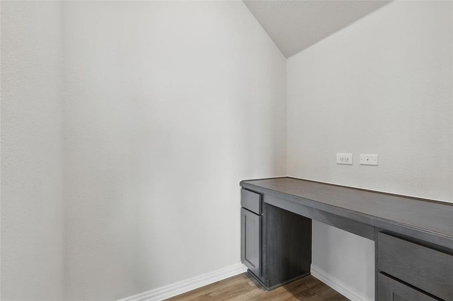 Unfurnished office with light wood-style flooring and lofted ceiling Unfurnished office with light wood-style flooring and lofted ceiling