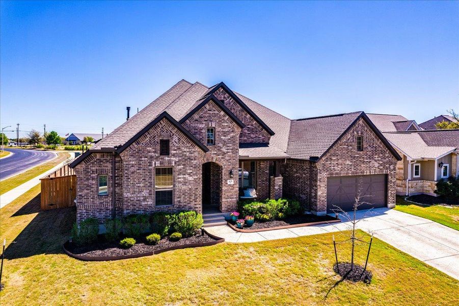View of front of house with brick siding, roof with shingles, a garage, and driveway View of front of house with brick siding, roof with shingles, a garage, and driveway