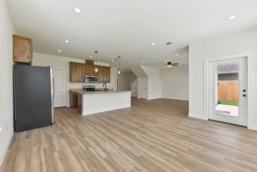 Kitchen with light wood look floors, visible vents, a sink, appliances with stainless steel finishes, and open floor plan