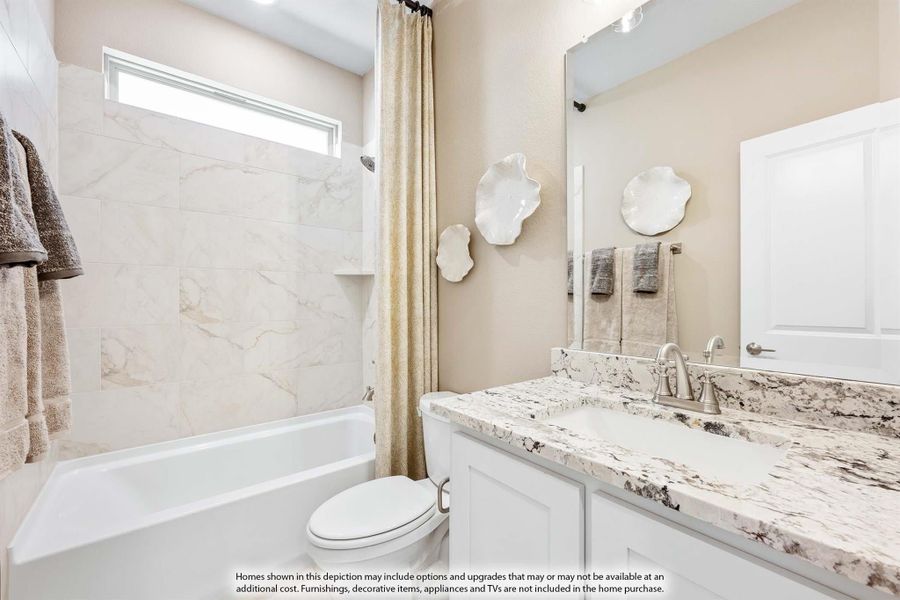 Bathroom with white cabinets, granite countertop, tub-shower combo with marble tile surround, and large mirror Bathroom with white cabinets, granite countertop, tub-shower combo with marble tile surround, and large mirror