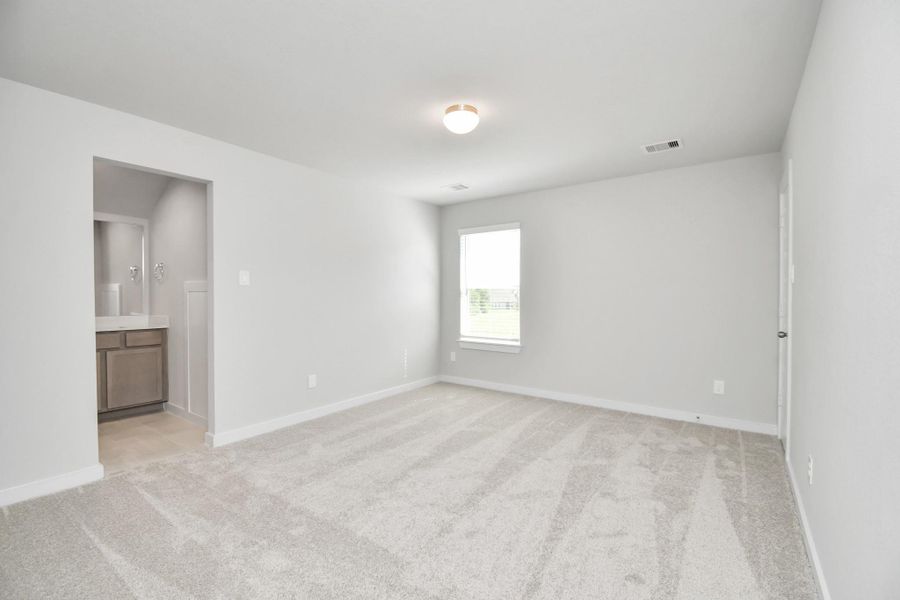 Secondary bedroom features plush carpeting, large windows that let in plenty of natural light, bright paint, and spacious closets. Sample photo of completed home with similar floor plan. Actual colors and selections may vary.