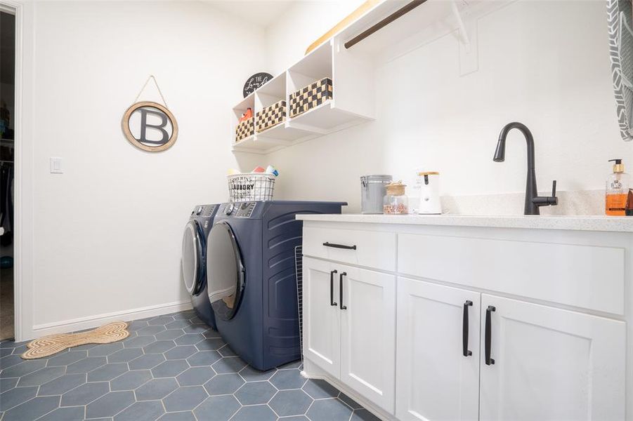 Laundry room with washer and dryer, dark tile patterned flooring, and cabinet space Laundry room with washer and dryer, dark tile patterned flooring, and cabinet space