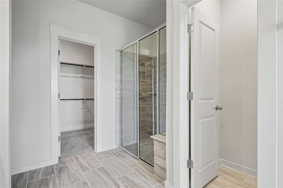 Bathroom with a shower with shower door and tile patterned floors