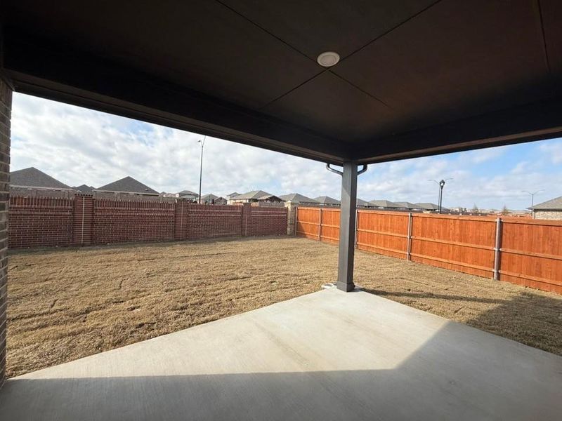 Fenced backyard with a patio area Fenced backyard with a patio area
