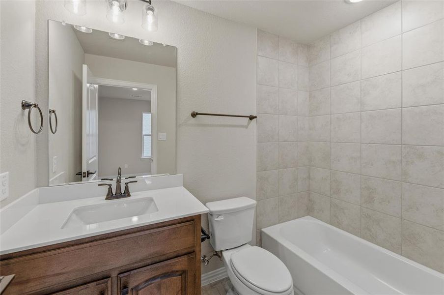 Bathroom vanity featuring a white rectangular sink, a white countertop, and dark wood-finish cabinetry