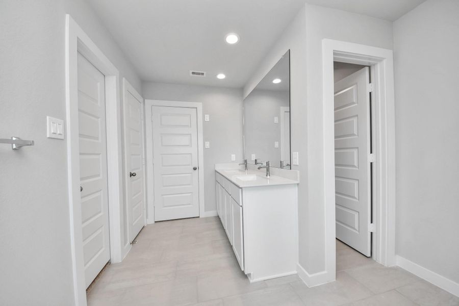 Elevate your daily routine at the elegant vanity, now equipped with double sinks, light countertops, modern hardware, and beautiful recessed lights. Sample photo of completed home with similar floor plan. Actual colors and selections may vary. Elevate your daily routine at the elegant vanity, now equipped with double sinks, light countertops, modern hardware, and beautiful recessed lights. Sample photo of completed home with similar floor plan. Actual colors and selections may vary.