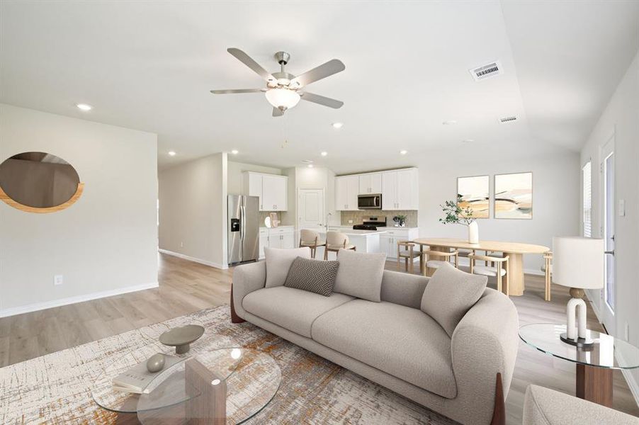 Living area featuring light wood finished floors, ceiling fan, vaulted ceiling, and recessed lighting