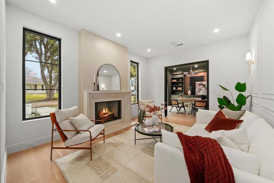 Living area with wood finished floors, a fireplace with flush hearth, and recessed lighting Living area with wood finished floors, a fireplace with flush hearth, and recessed lighting