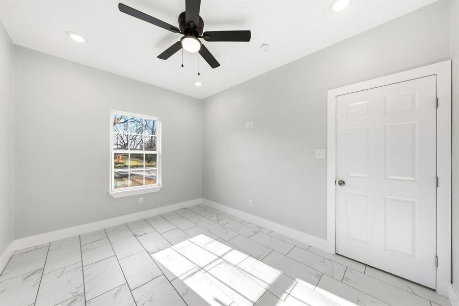 Spare room with ceiling fan, light marble finish flooring, and recessed lighting