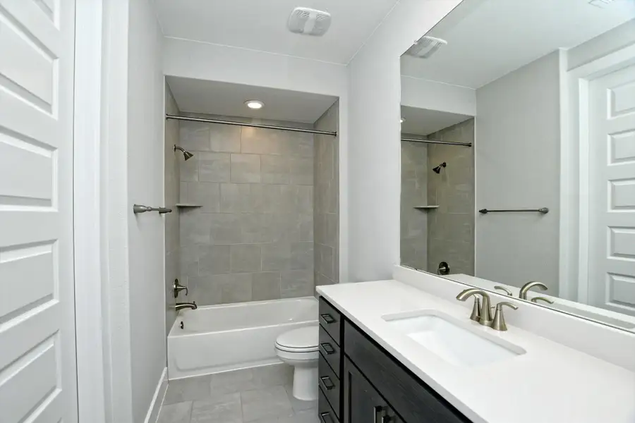 Bathroom featuring toilet, vanity, and bathtub / shower combination